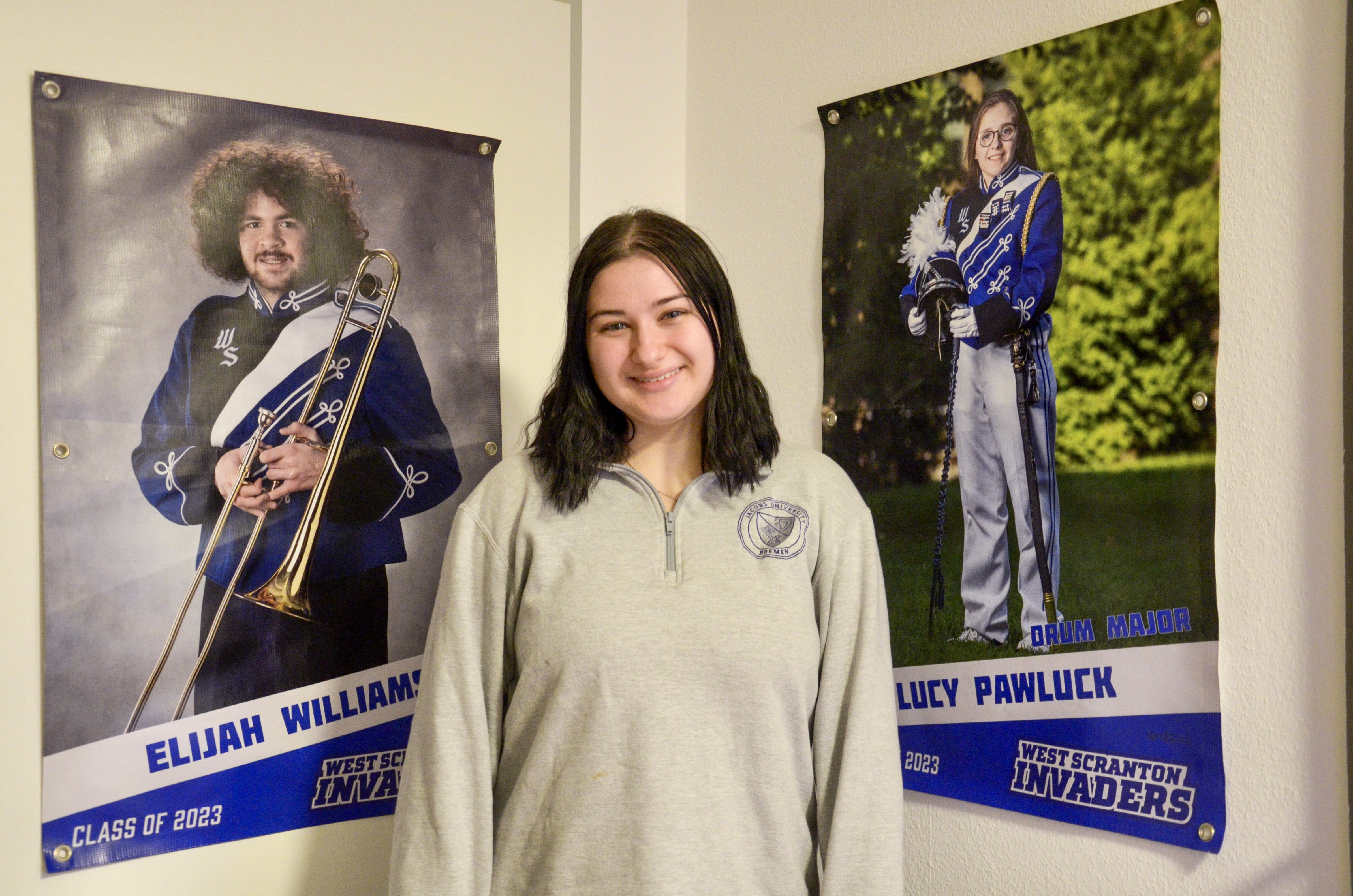 Student Bella in front of her collection of posters