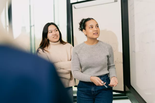 Students going through a presentation with a white board
